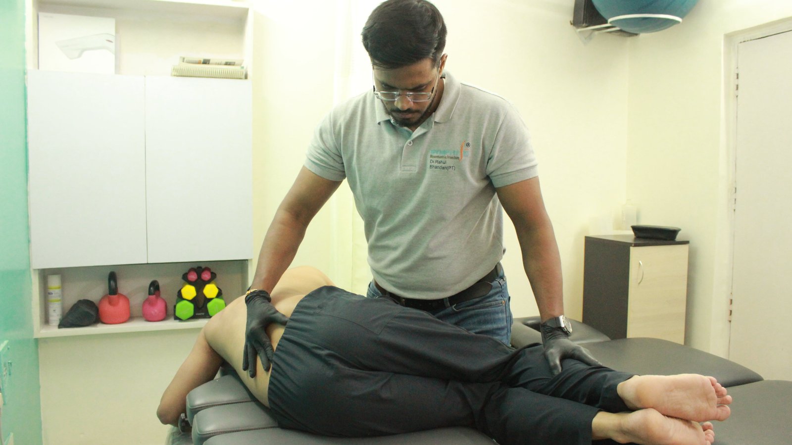 Physiotherapist performing manual lumbar spine therapy on a patient at Symphysio, Sarita Vihar