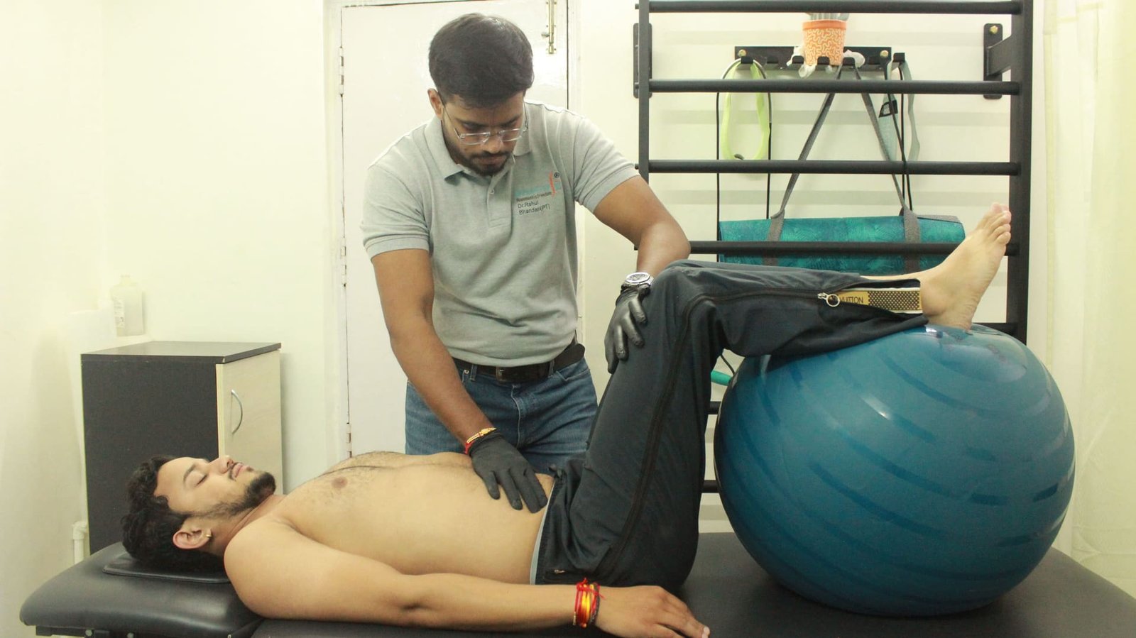 Physiotherapist guiding a core stability exercise using a stability ball at Symphysio, Sarita Vihar